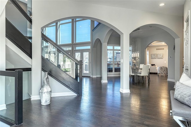 living room with stairs, wood finished floors, baseboards, a high ceiling, and recessed lighting