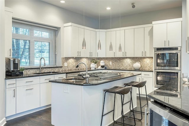 kitchen featuring a sink, stainless steel appliances, recessed lighting, tasteful backsplash, and wine cooler