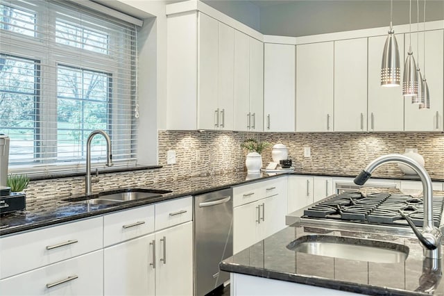 kitchen with a sink, dark stone counters, and tasteful backsplash