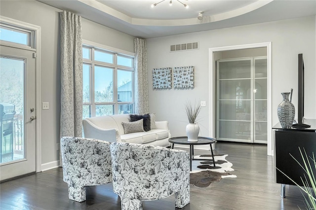 living area featuring baseboards, visible vents, and dark wood-style floors