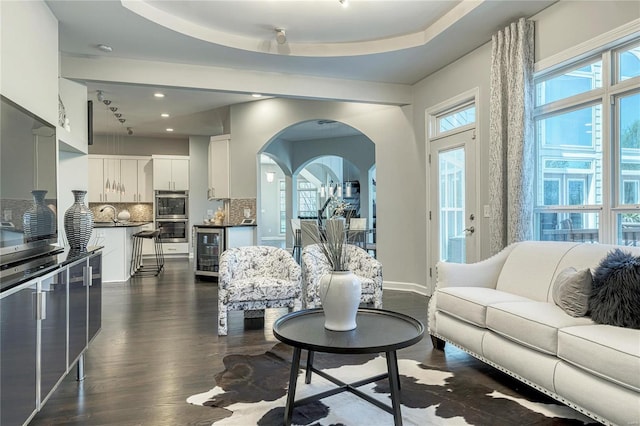 living room featuring beverage cooler, recessed lighting, dark wood-style floors, and a healthy amount of sunlight