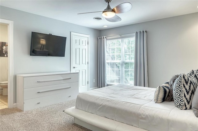 carpeted bedroom with ceiling fan, connected bathroom, and visible vents