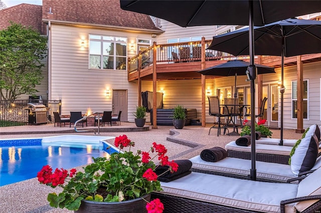 rear view of house featuring roof with shingles, a deck, an outdoor pool, an outdoor fire pit, and a patio