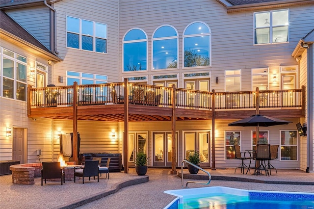 back of house featuring a patio, an outdoor pool, and an outdoor fire pit