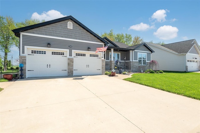 craftsman house with stone siding, concrete driveway, a front yard, and a garage