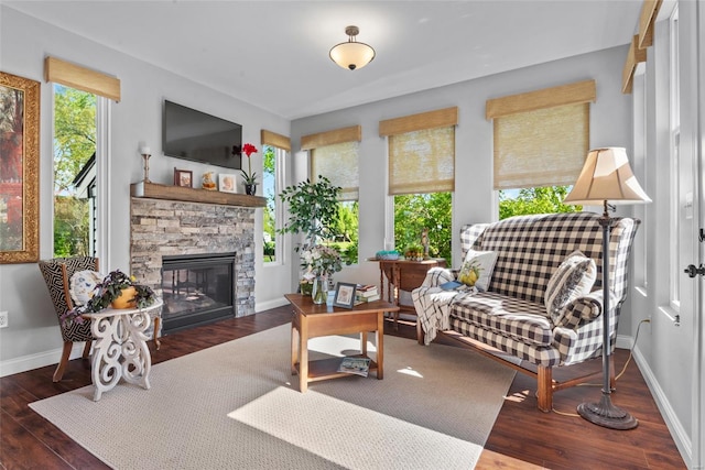 sunroom / solarium featuring baseboards, wood finished floors, and a healthy amount of sunlight