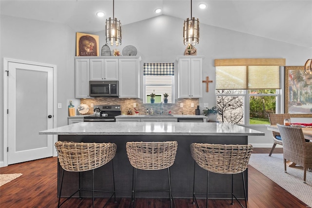 kitchen featuring stainless steel microwave, electric stove, white cabinets, and a sink