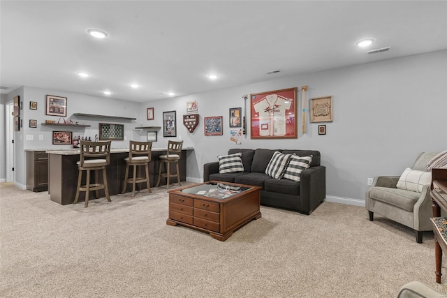 living room with recessed lighting, indoor wet bar, visible vents, and light colored carpet