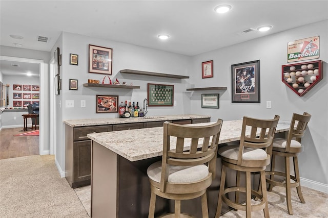 bar with visible vents, baseboards, indoor bar, and a sink