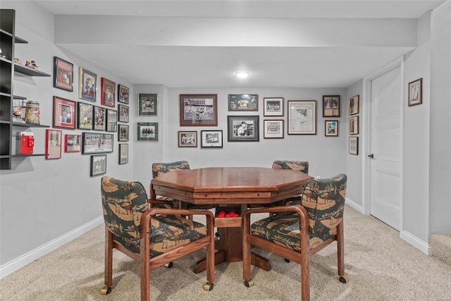 dining room featuring baseboards and light carpet