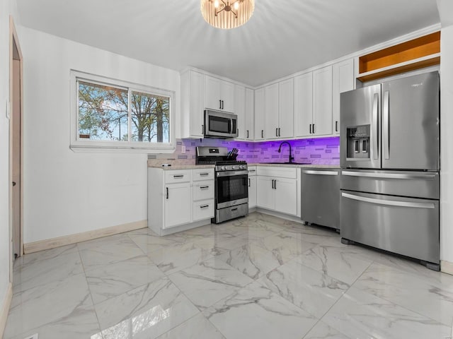 kitchen featuring white cabinets, marble finish floor, stainless steel appliances, and a sink
