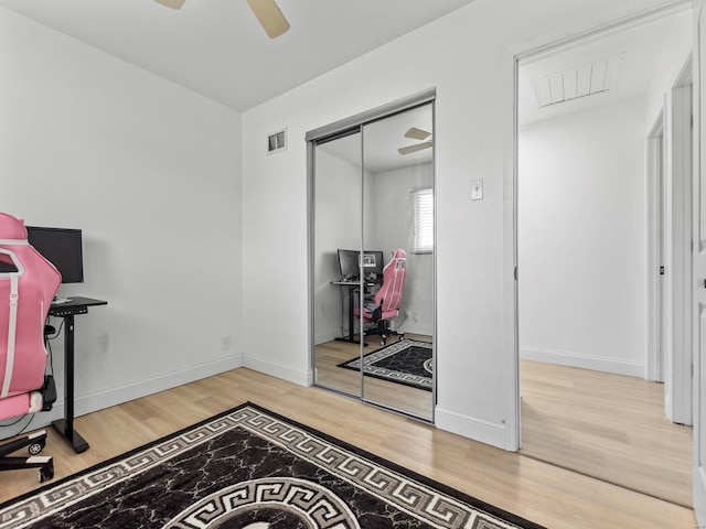 office area featuring baseboards, a ceiling fan, wood finished floors, and visible vents