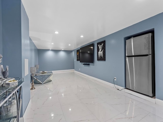 unfurnished room with recessed lighting, marble finish floor, and baseboards