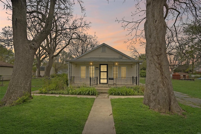 bungalow featuring a yard and covered porch