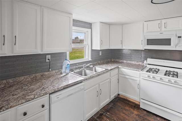 kitchen with white cabinetry, a sink, and white appliances