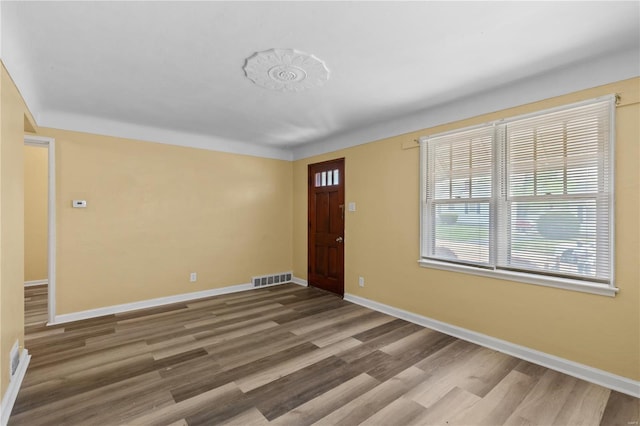 foyer featuring visible vents, baseboards, and wood finished floors