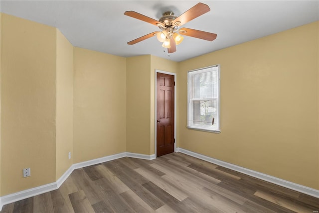 spare room featuring baseboards, a ceiling fan, and wood finished floors