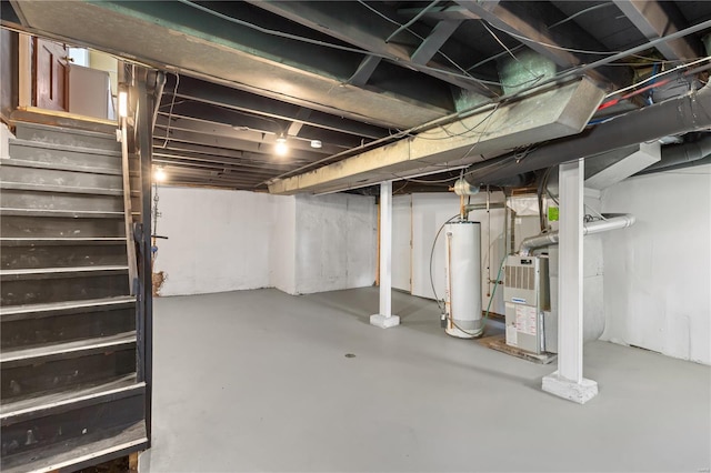 unfinished below grade area with stairs, heating unit, and gas water heater