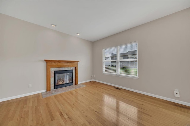 unfurnished living room with visible vents, light wood-style floors, and baseboards