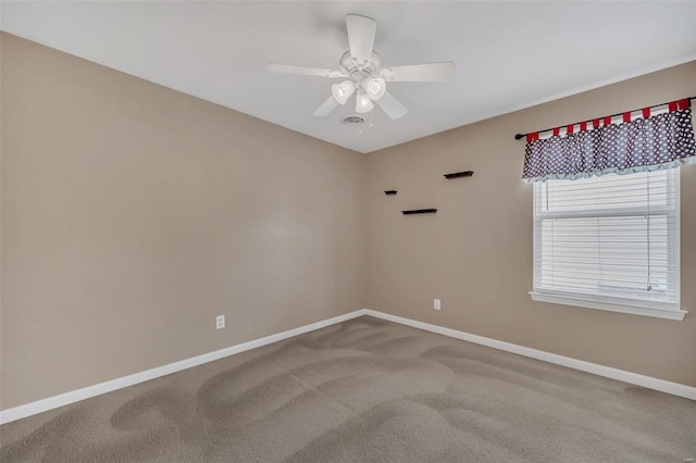 carpeted empty room featuring baseboards and a ceiling fan