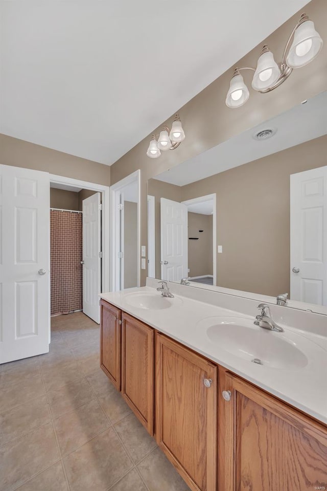 bathroom with double vanity, visible vents, tile patterned flooring, and a sink