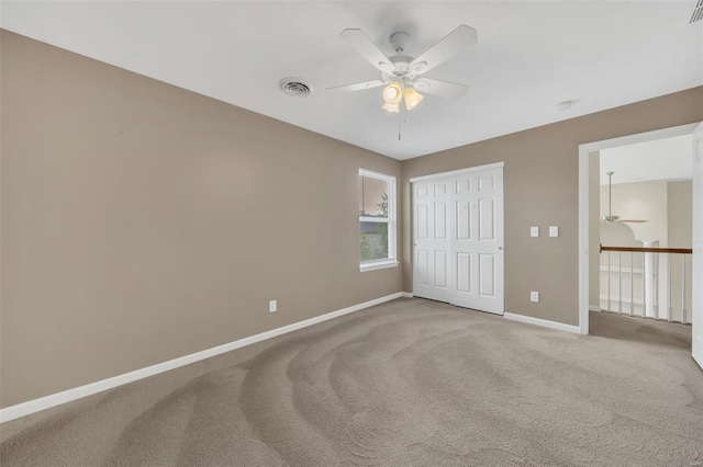 unfurnished bedroom with a closet, ceiling fan, visible vents, light carpet, and baseboards