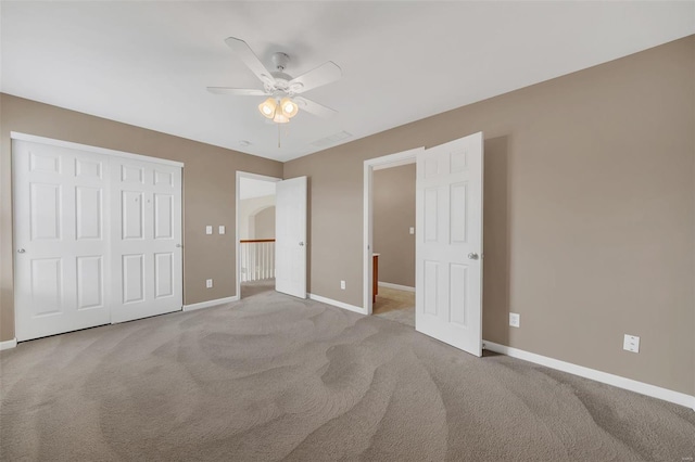 unfurnished bedroom with carpet flooring, a closet, a ceiling fan, visible vents, and baseboards