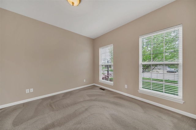 empty room featuring baseboards, a healthy amount of sunlight, and carpet floors