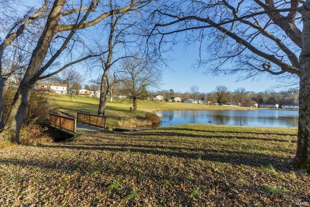 view of property's community featuring a lawn and a water view