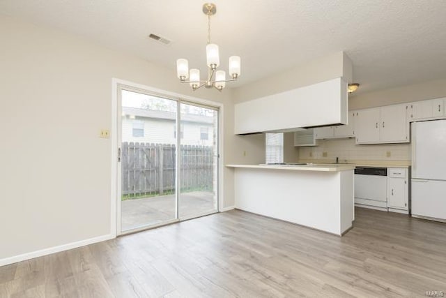 kitchen with light wood-style floors, white appliances, an inviting chandelier, light countertops, and visible vents