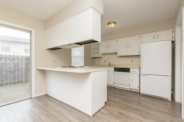kitchen with light countertops, light wood-style floors, white cabinets, and white appliances