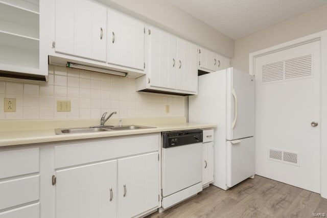 kitchen featuring light countertops, visible vents, a sink, white appliances, and tasteful backsplash