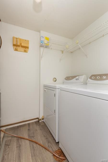 washroom featuring separate washer and dryer, baseboards, light wood-style floors, and laundry area