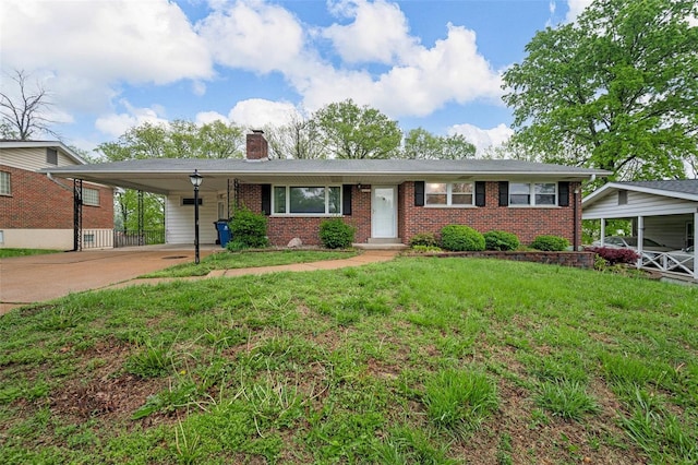 ranch-style home with brick siding, driveway, a chimney, and a front lawn