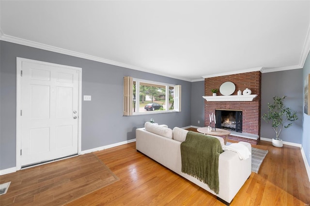 living room with baseboards, ornamental molding, wood finished floors, and a fireplace