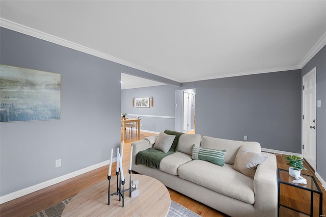 living area featuring crown molding, baseboards, and wood finished floors
