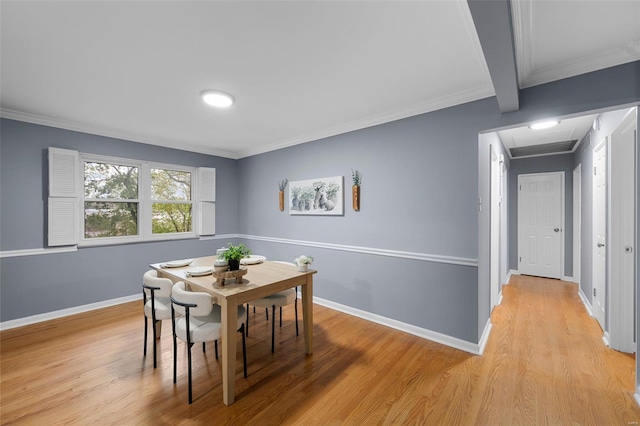 dining space featuring light wood-type flooring, baseboards, and crown molding