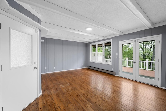 unfurnished room featuring a textured ceiling, a baseboard heating unit, beam ceiling, and hardwood / wood-style flooring
