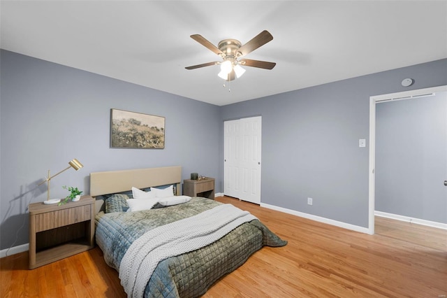 bedroom with baseboards, a ceiling fan, a closet, and wood finished floors