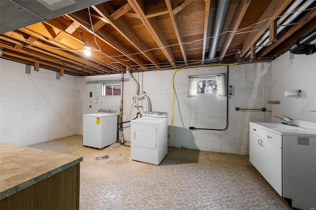 clothes washing area featuring a sink and washer and clothes dryer