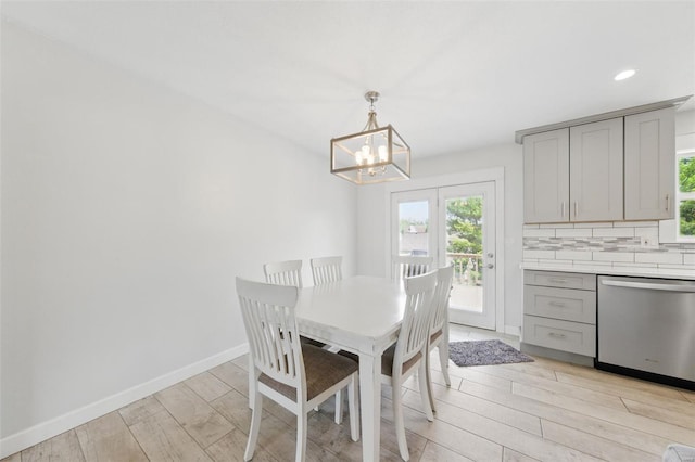 dining space featuring plenty of natural light, light wood-style floors, baseboards, and an inviting chandelier