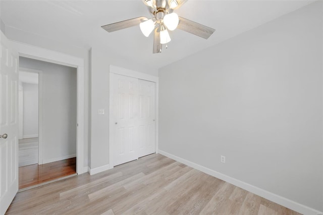 unfurnished bedroom with light wood-style floors, a ceiling fan, baseboards, and a closet
