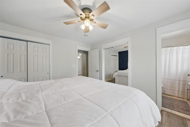 bedroom with ceiling fan, multiple closets, and wood finished floors