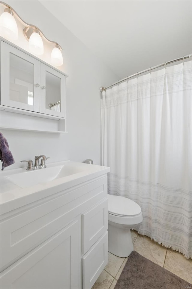 full bathroom with toilet, tile patterned flooring, and vanity