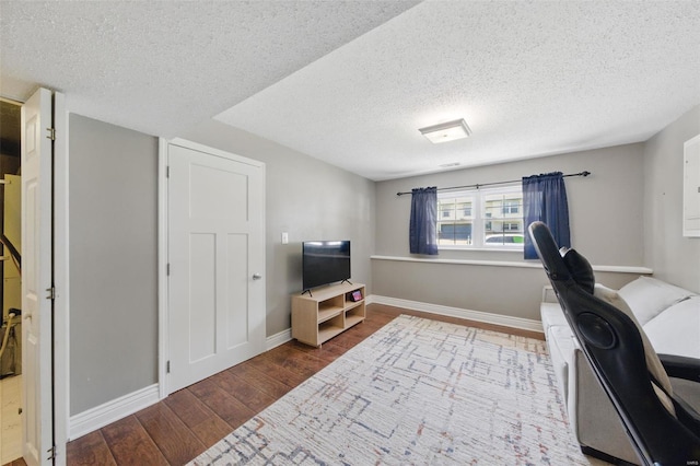 office area featuring baseboards, a textured ceiling, and wood finished floors