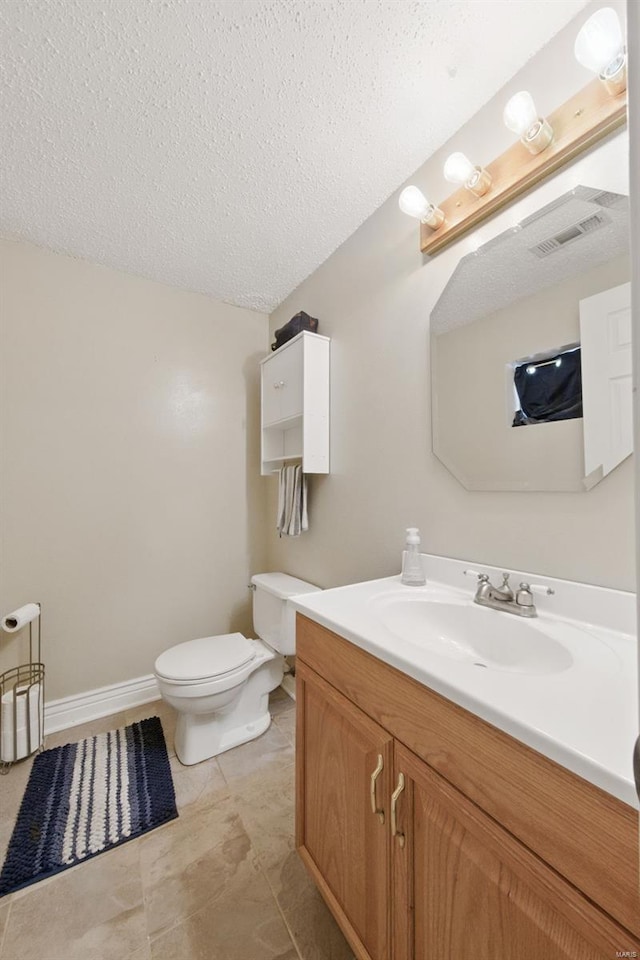 bathroom featuring vanity, toilet, a textured ceiling, and visible vents