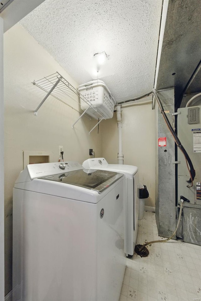 laundry area featuring washer and dryer, a textured ceiling, laundry area, and light floors