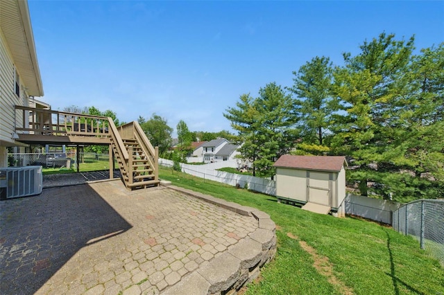 view of yard with a deck, a patio, a storage unit, central AC unit, and stairs