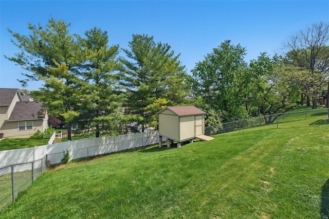 view of yard featuring an outdoor structure, a fenced backyard, and a storage unit
