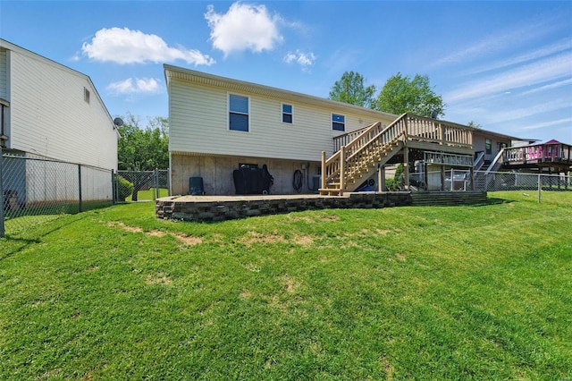 back of property featuring a fenced backyard, stairs, a lawn, and a wooden deck